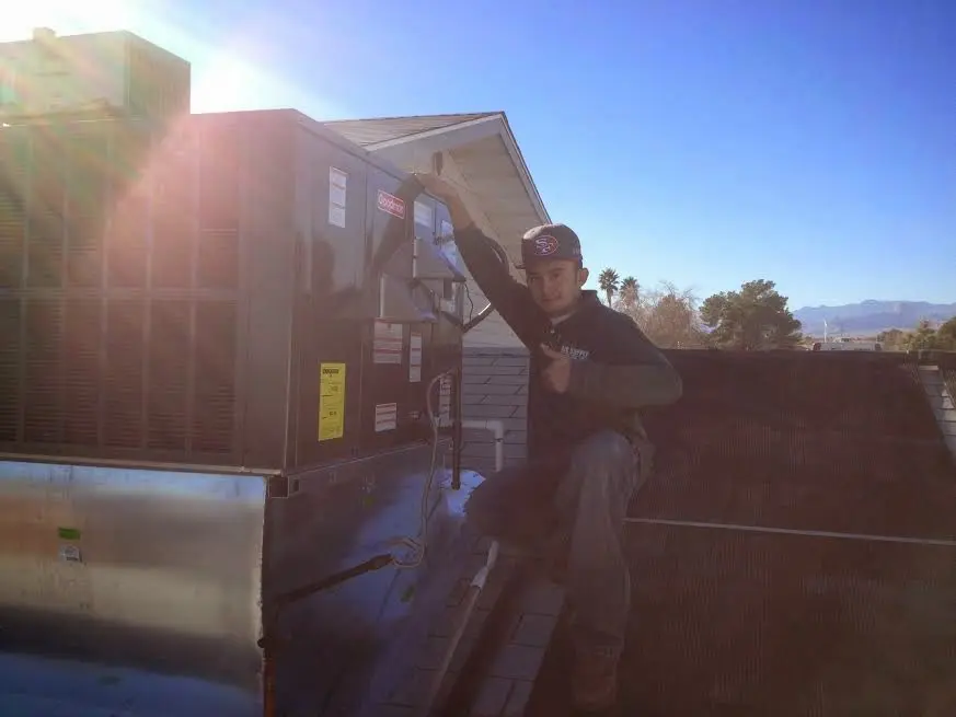 HVAC technician performing HVAC Inspection on a rooftop unit in Coffeyville
